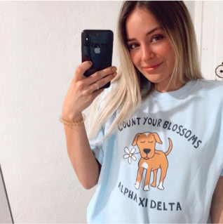 Alpha Xi Delta member wearing Life is Good t-shirt with an image of a dog and flower